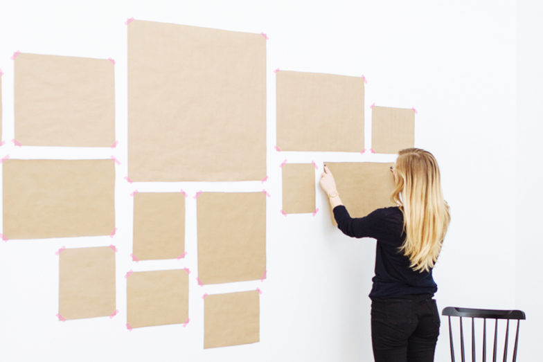 woman putting up templates for gallery wall