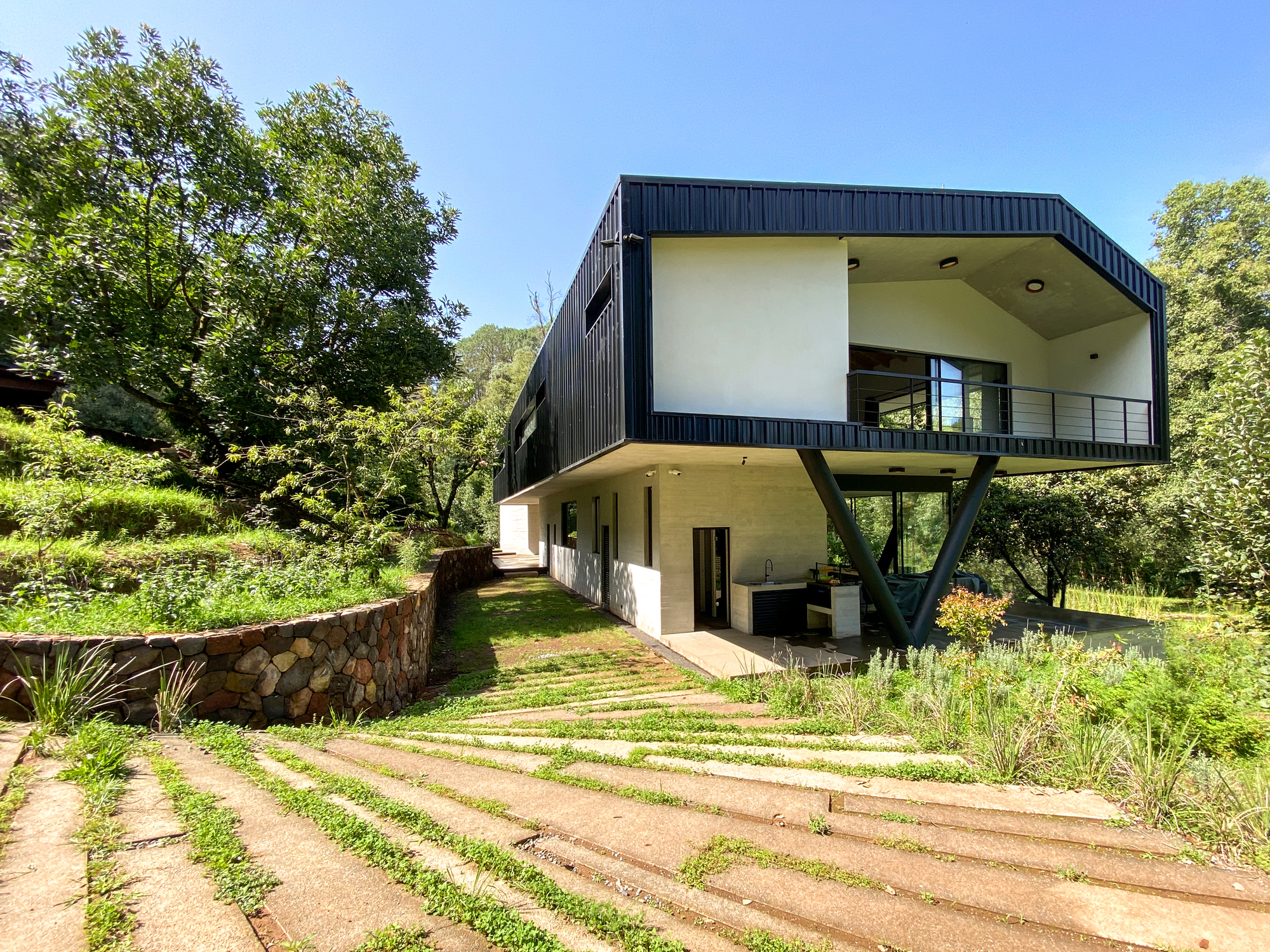 Cantilevered and gabled upper level of the home with living spaces and bedrooms