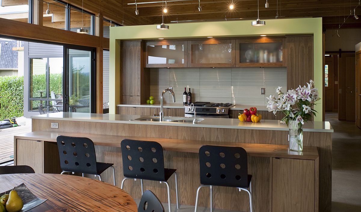 Contemporary kitchen with a wooden island and breakfast bar along with a hint of light green thrown into the mix