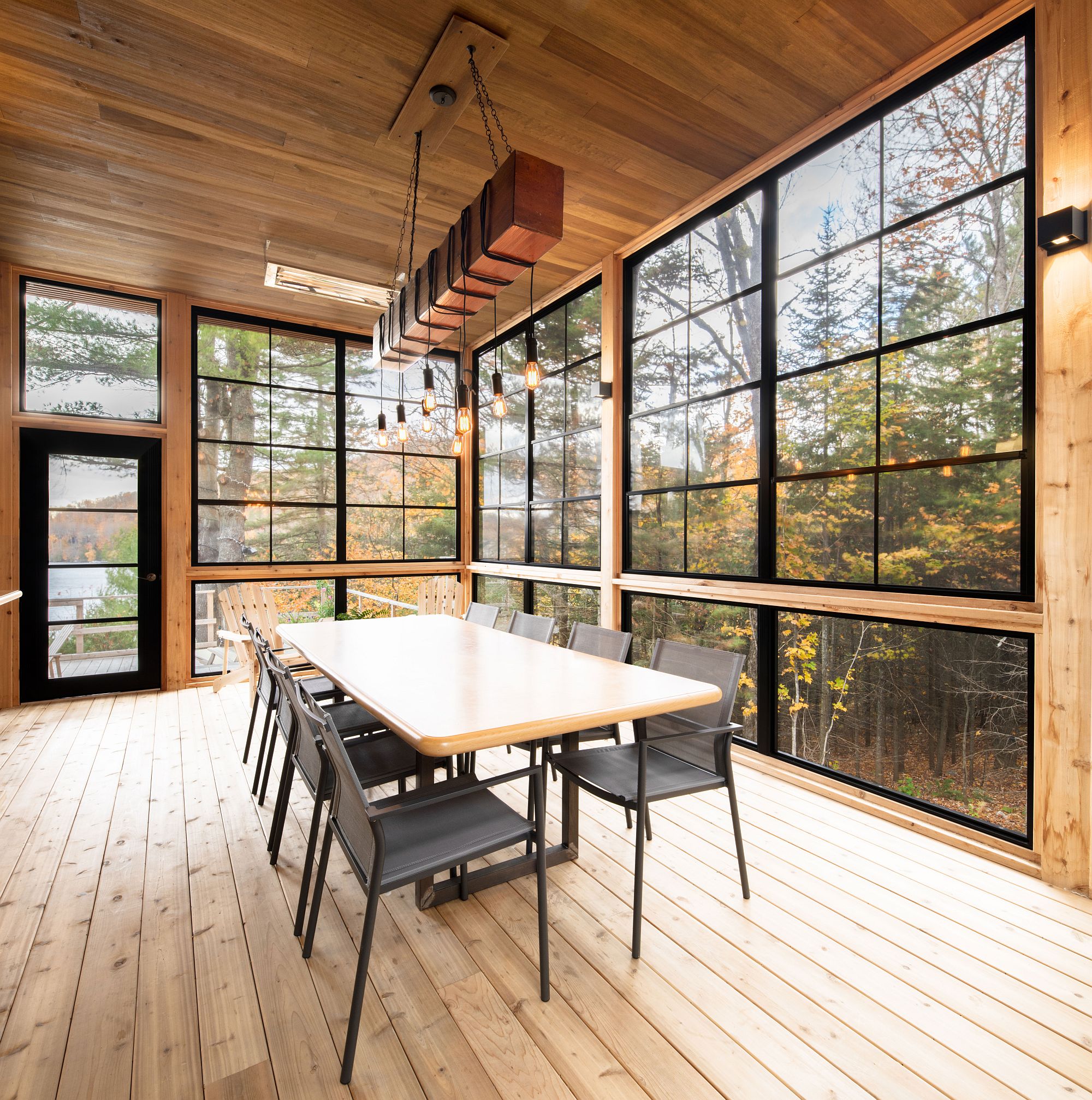 Dark framed windows and doors usher nature into the expansive dining space