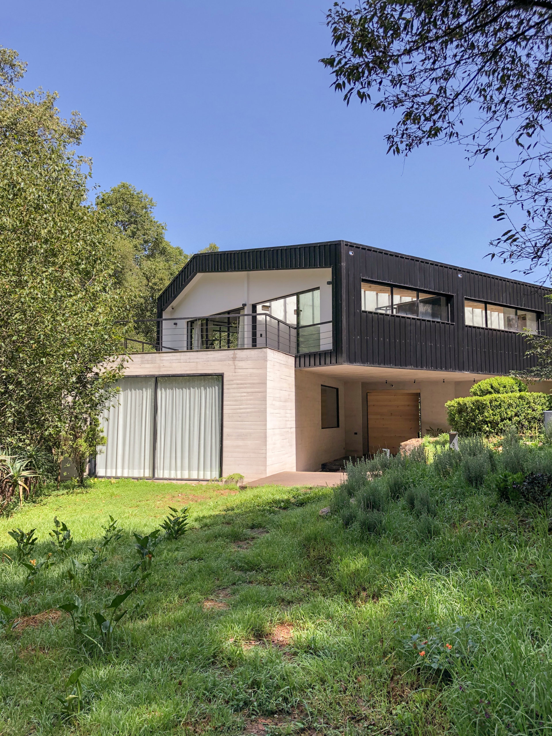 Dark metallic exterior of the house along with glass and concrete give it a modern sheen