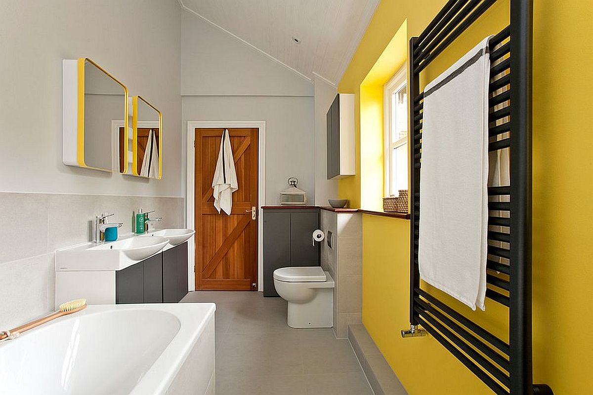 Dashing accent wall in yellow for the contemporary bathroom in yellow and gray