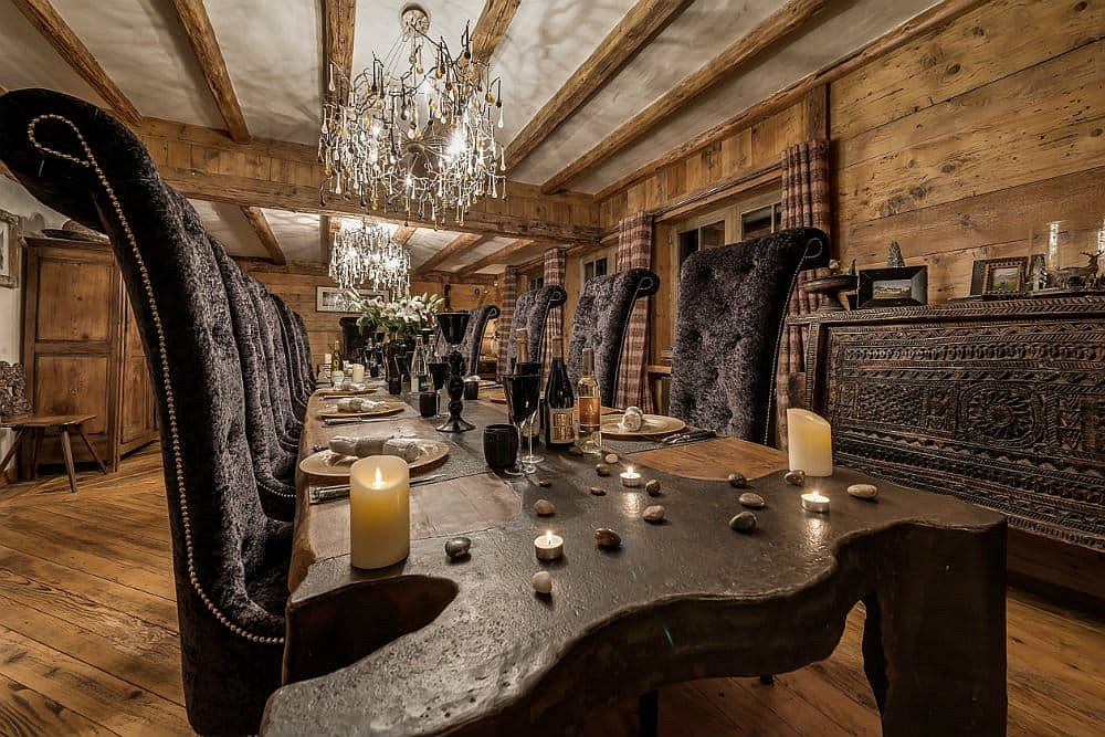 Dining space of the luxurious chalet with large wooden dining table and a fabulous credenza in the backdrop