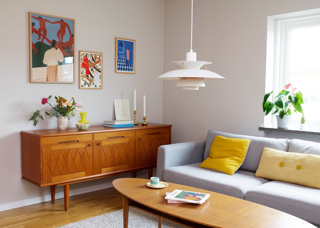 corner of mid century modern living space with carved credenza and low hanging light