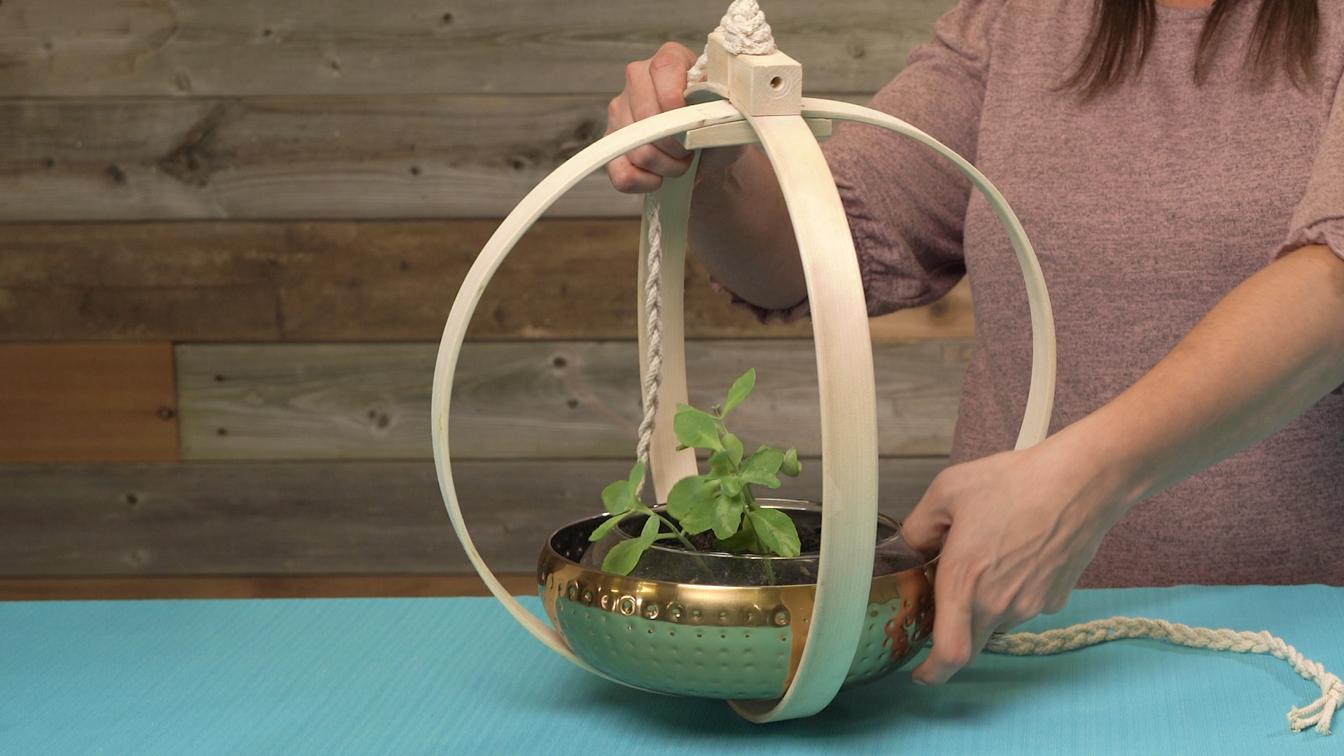 inserting bowl with plant into center of boho indoor hanging planter