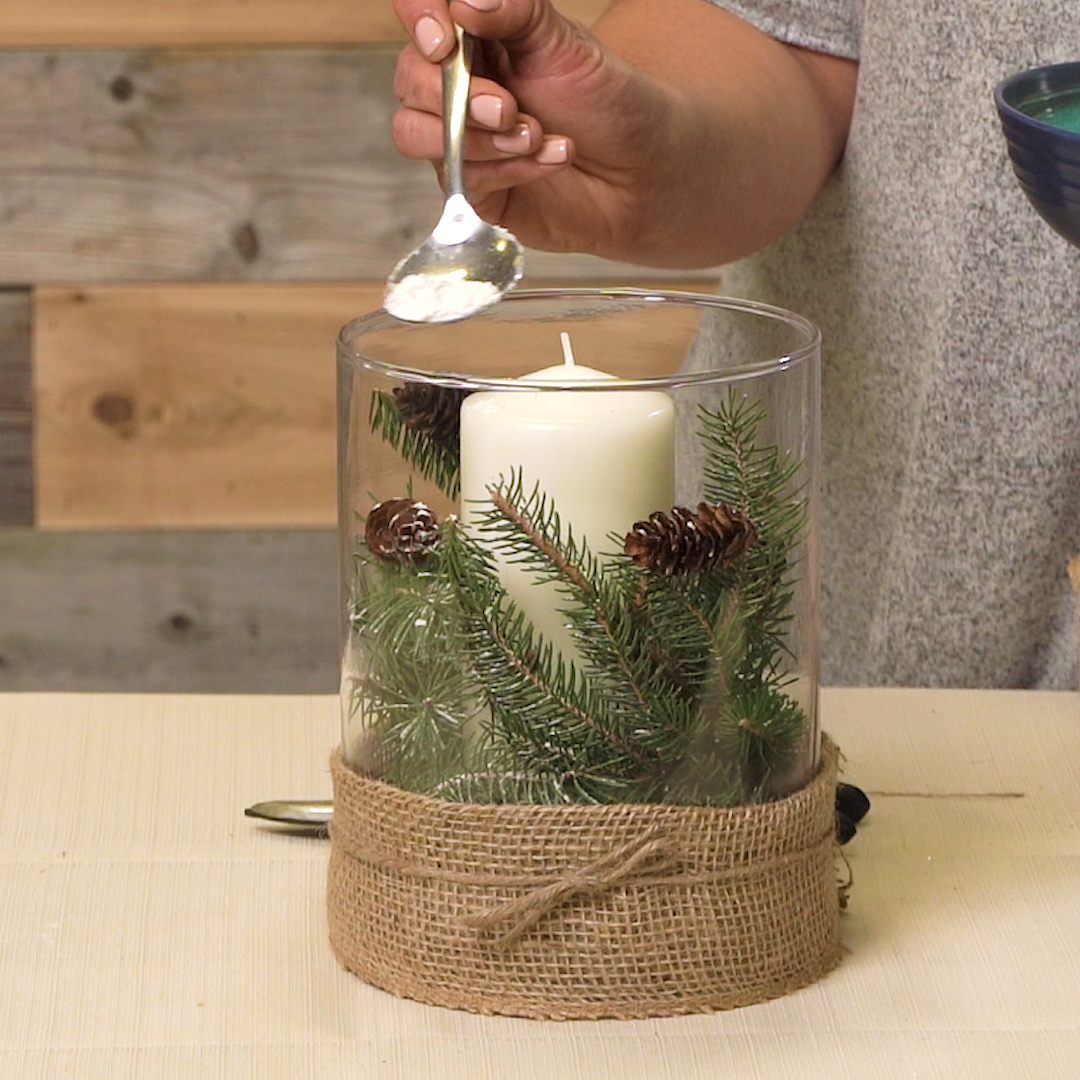 sprinkling fake snow on winter centerpiece