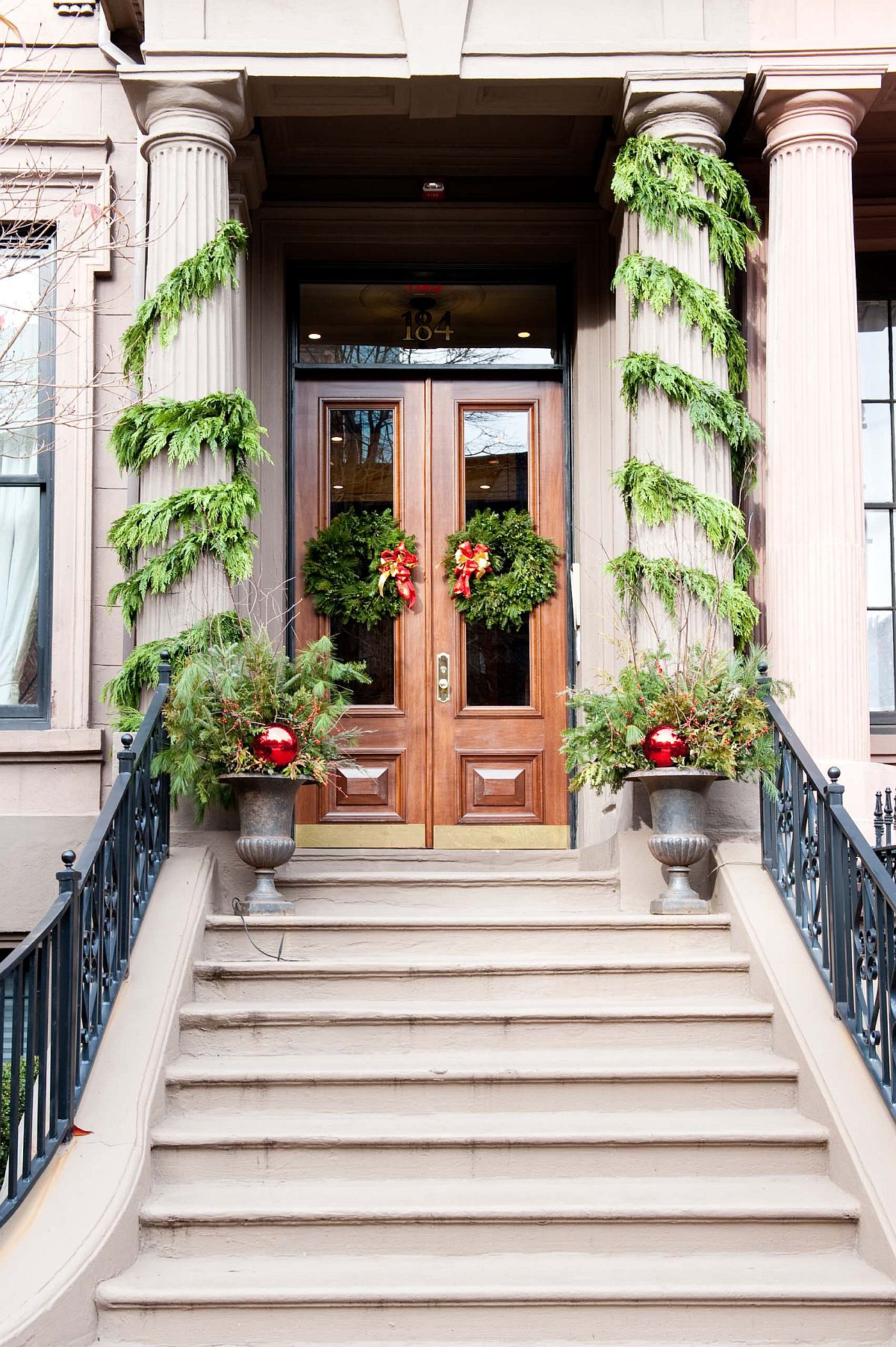 Simple and elegant evergreen wreaths and garlands can turn the entryway into an absolute showstopper