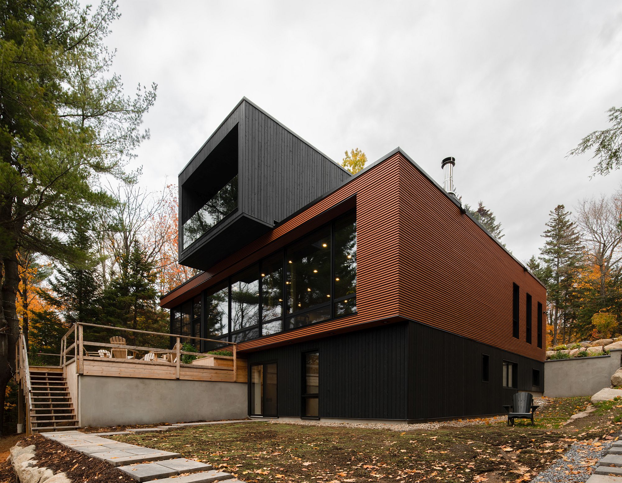 Spacious and elegant modern deck extending from the house offers lake and forest views