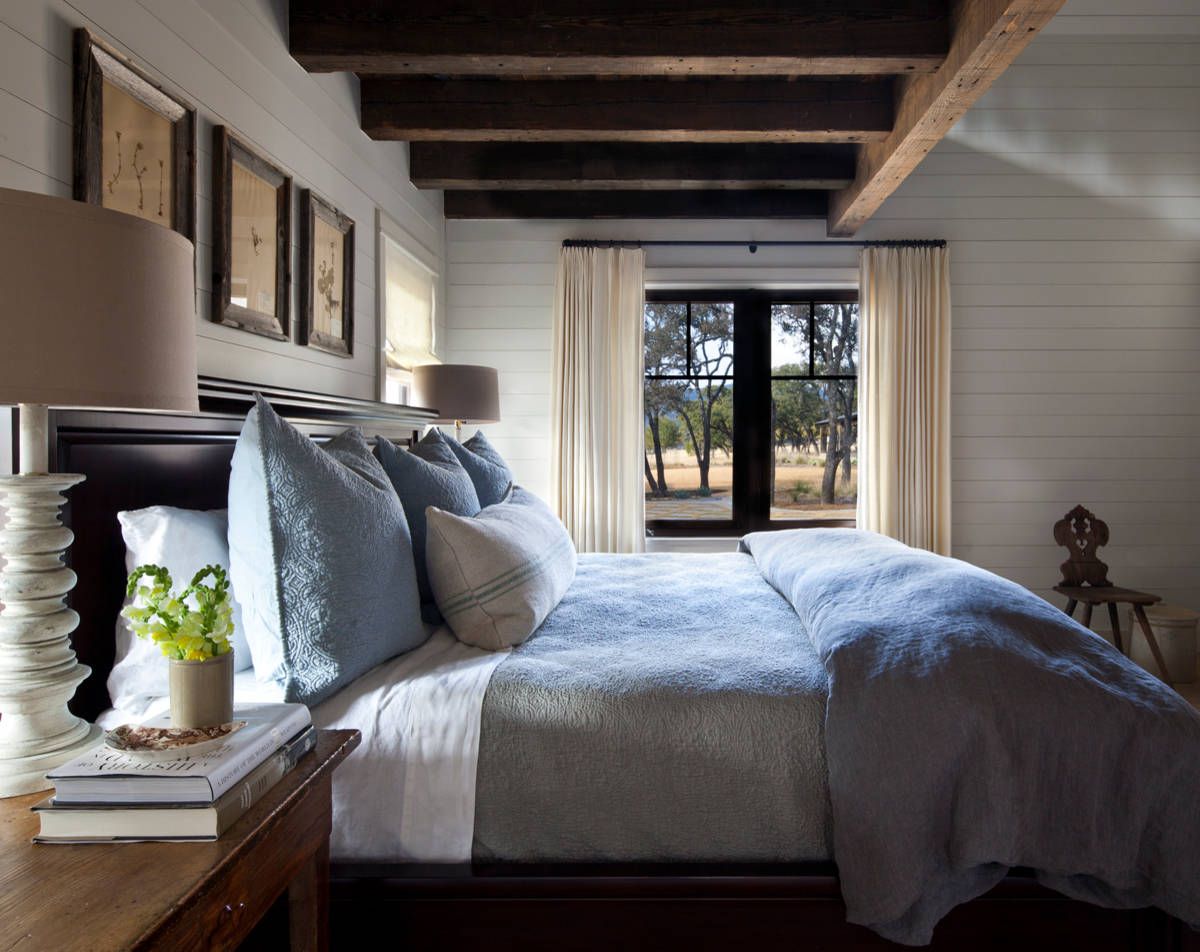 Wood and white bedroom where blue bedding ushers in a hint of color