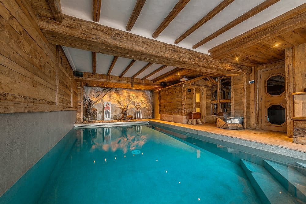 Wooden walls, doors and ceiling beams add warmth to the indoor swimming pool