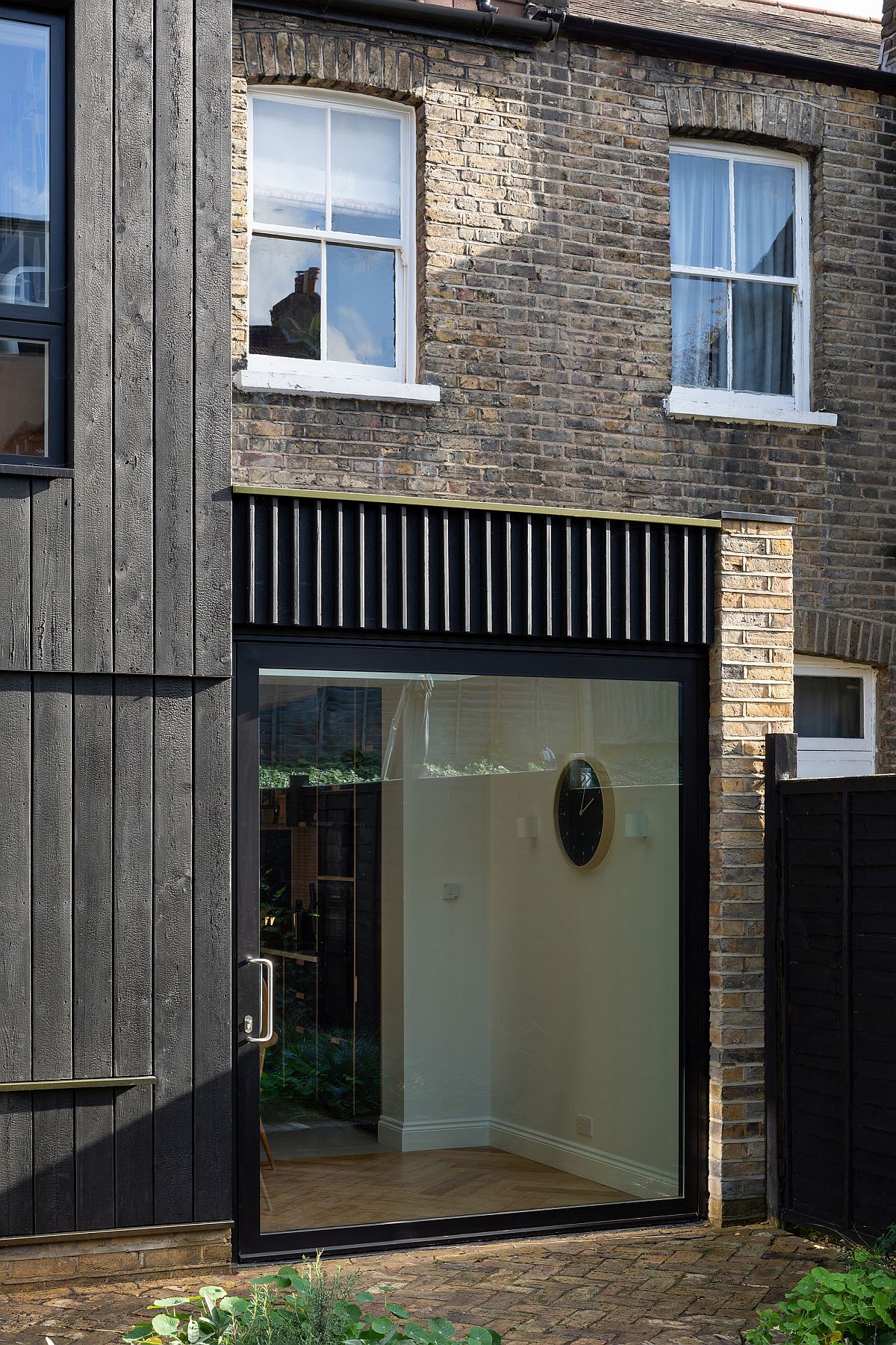 Charred timber extension sits next to timeless brick walls