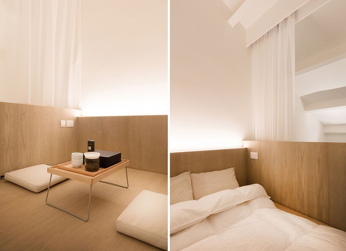 Closer look at the loft level bedroom of the apartment in wood and white