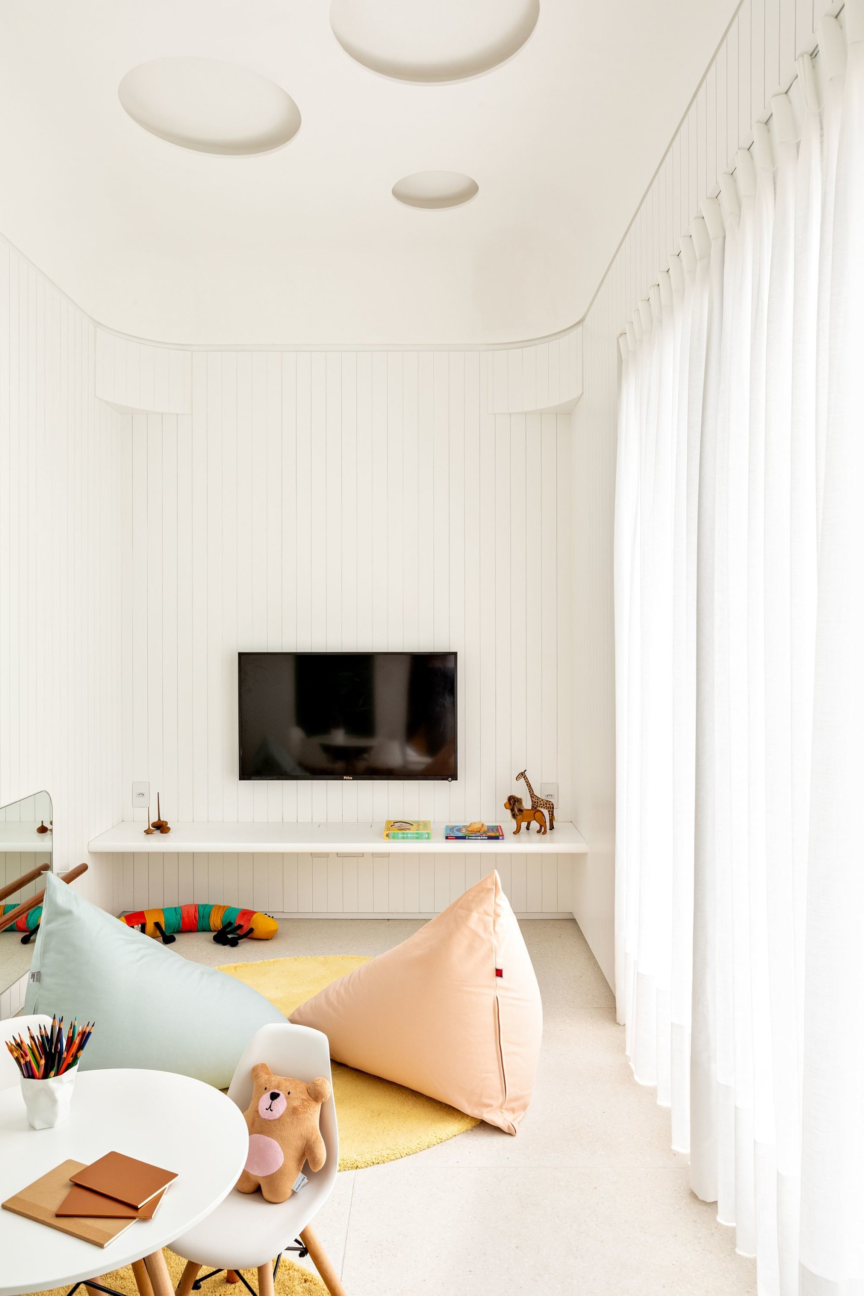 Contemporary kids' play area in white with custom storage units