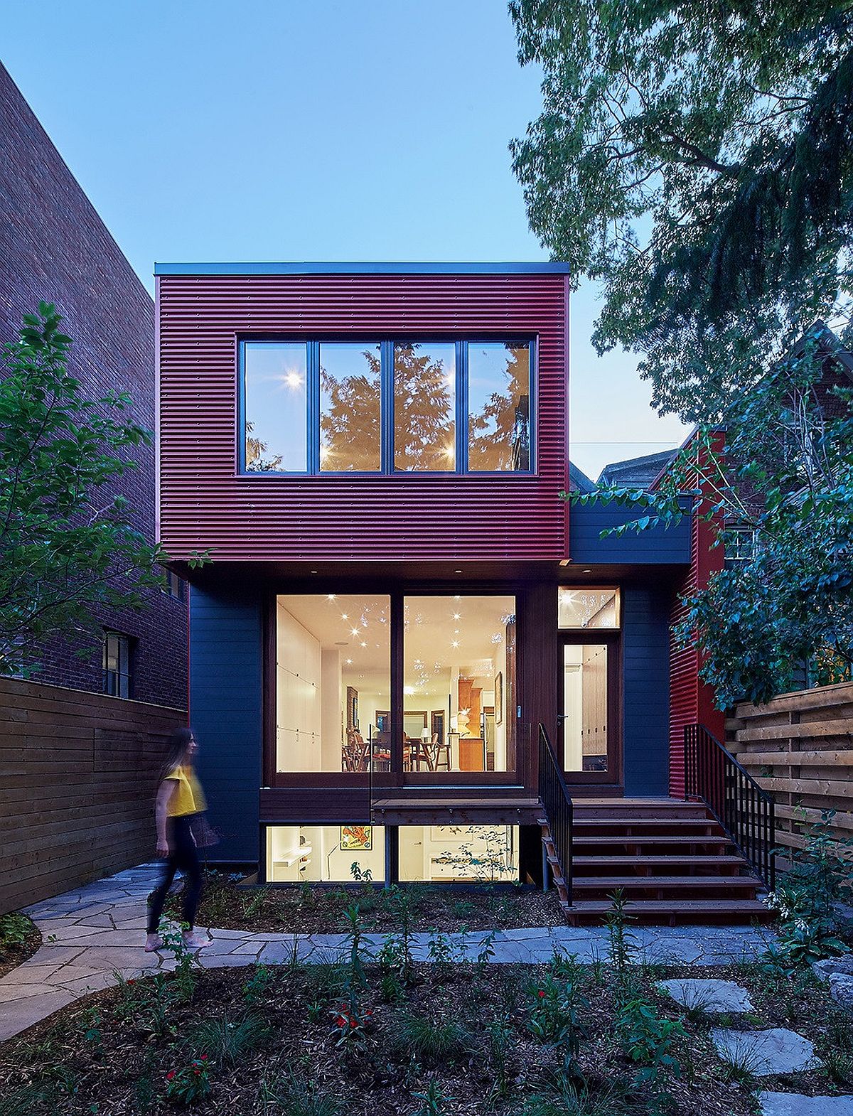 Contemporary red exterior of the home with dark gray and glass thrown into the mix