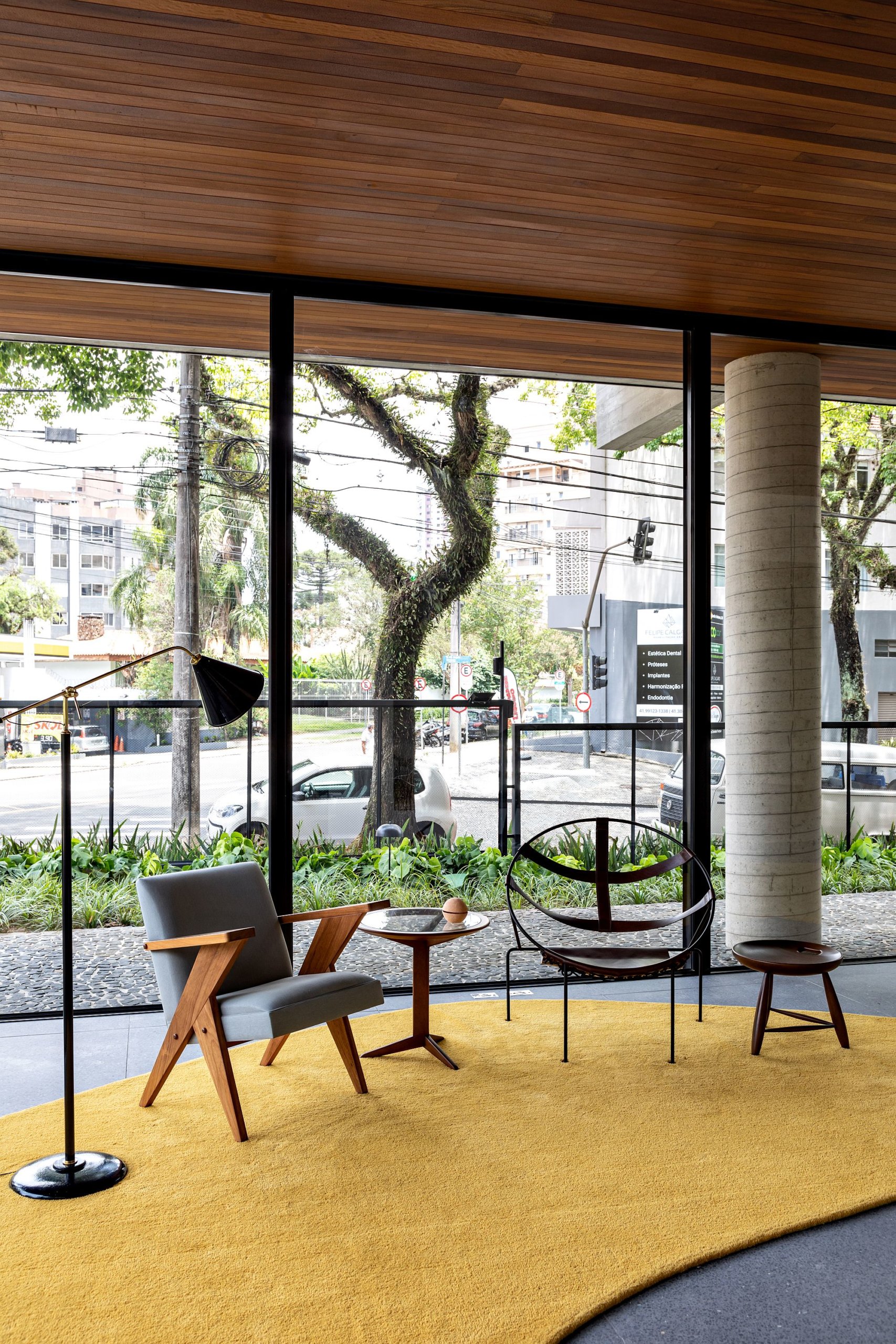 Glass walls, woodsy ceiling and a bright yellow carpet shape the hall of the building