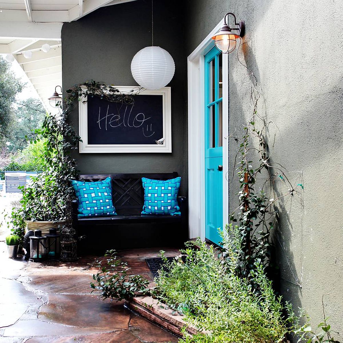 Gorgeous blue door coupled with blue cushions on the bench add color to the gray and white exterior