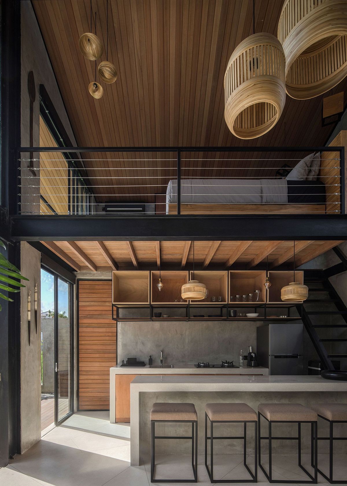 Industrial style home in Indonesia with a loft level bedroom above the kitchen