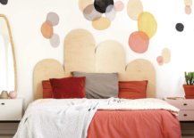 Red bed with pillows and geometric pattern in wall