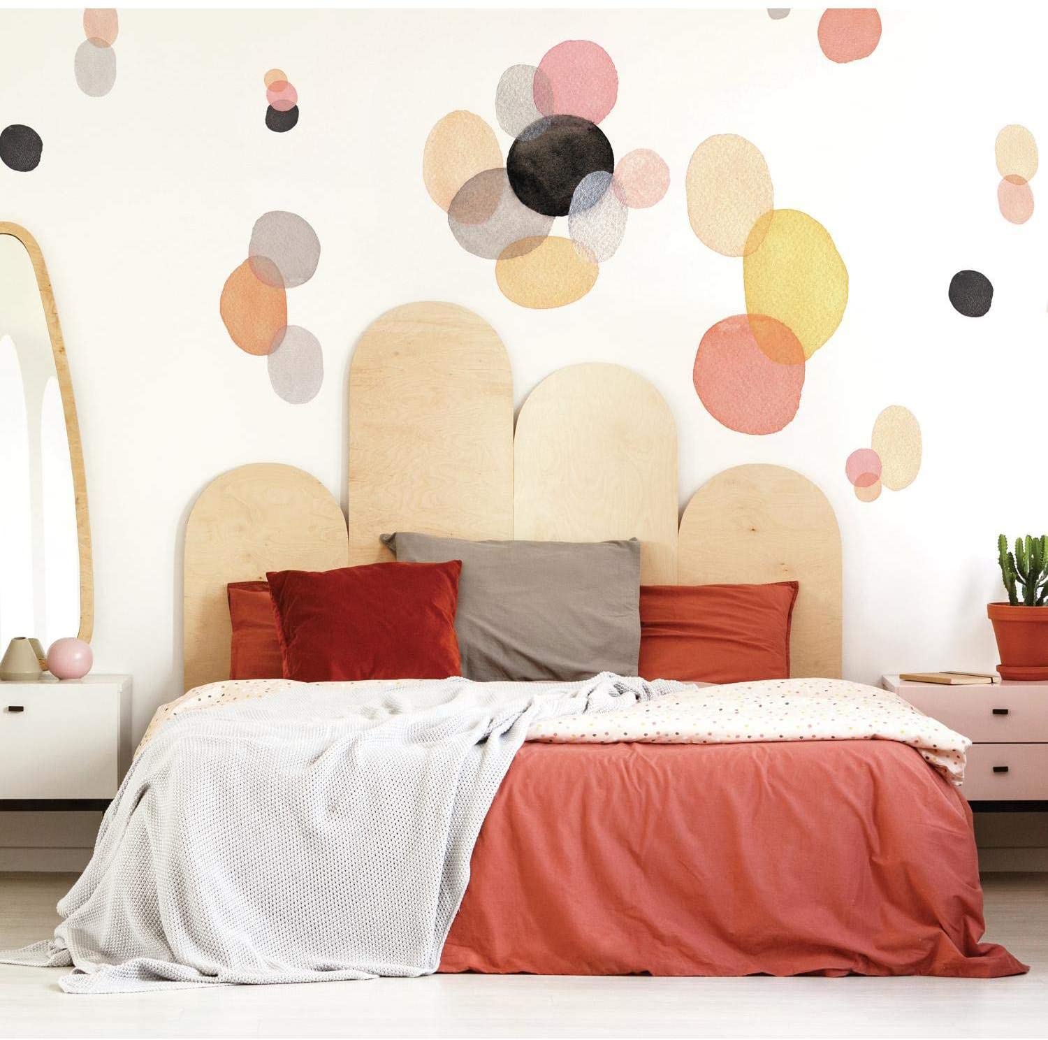 Red bed with pillows and geometric pattern in wall