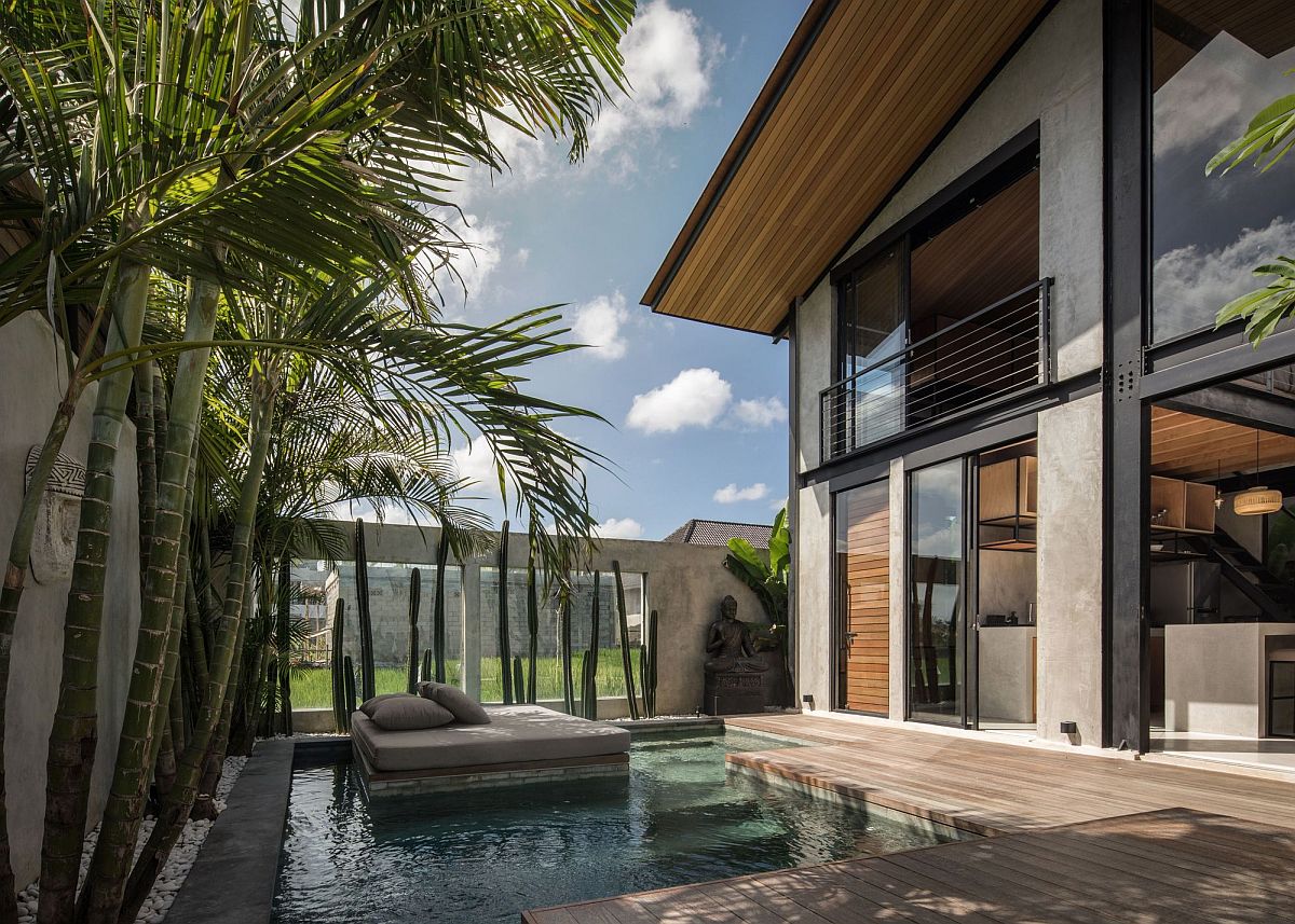 Relaxing sunbed at the center of the pool with a lovely wooden deck next to it