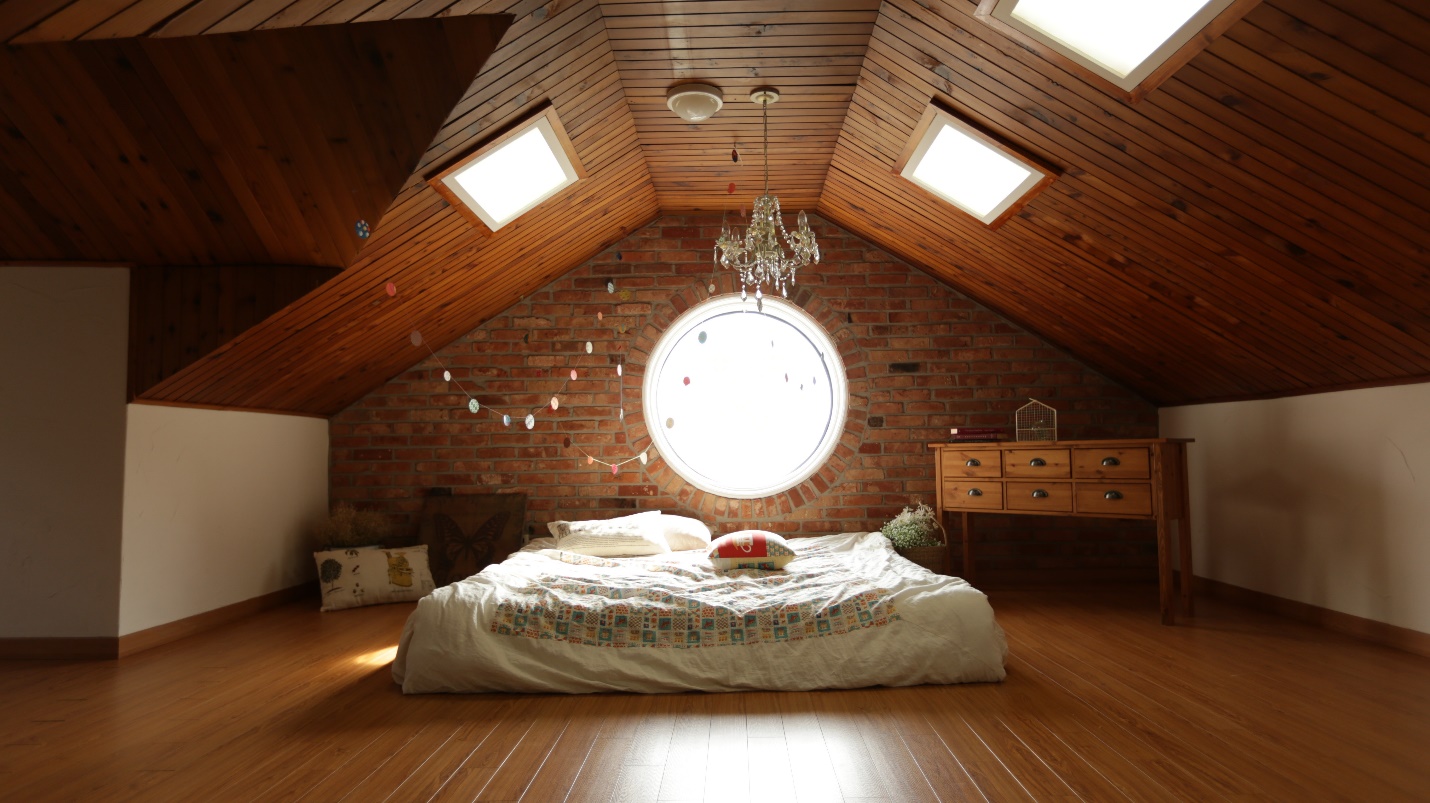 loft bedroom with slanted ceiling and skylight windows