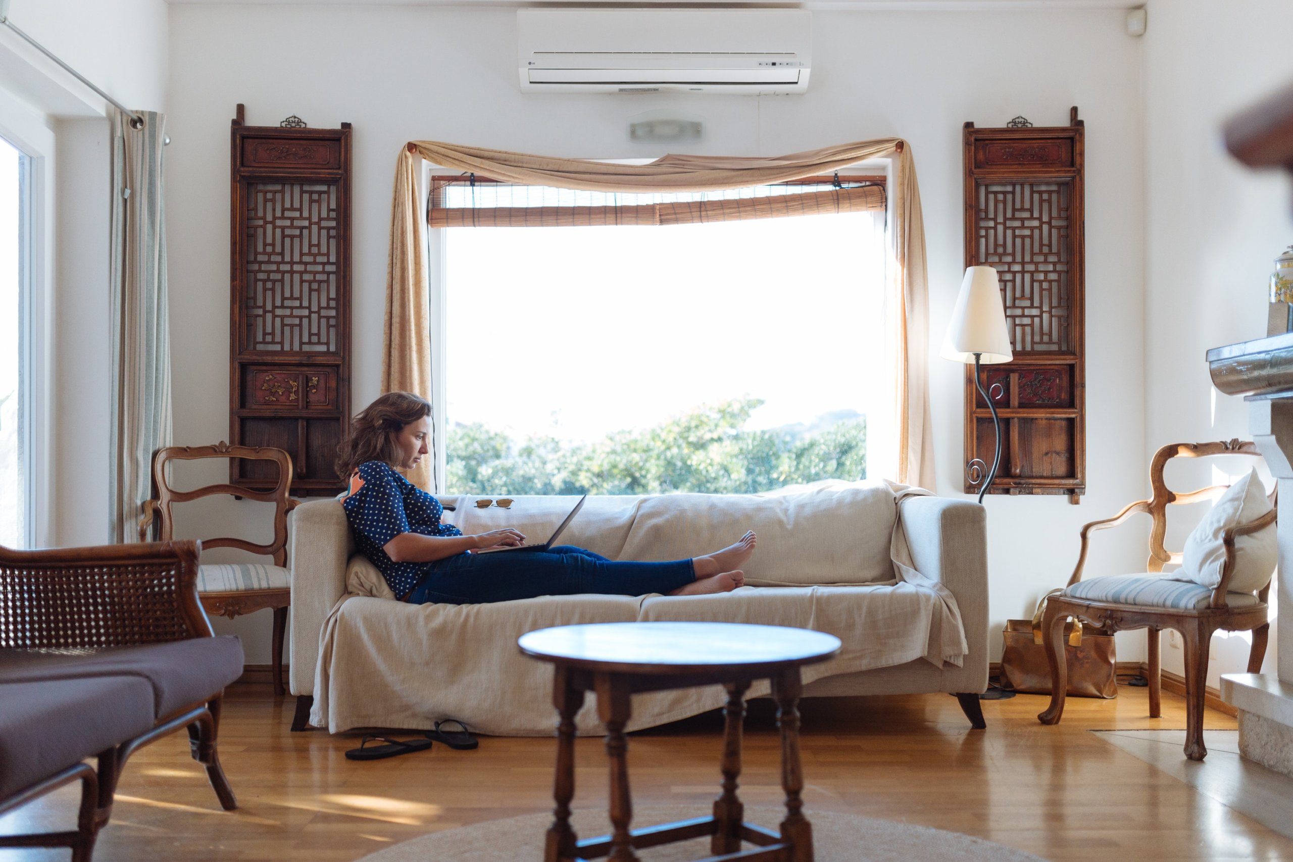 Woman sitting on a chair with big window behind