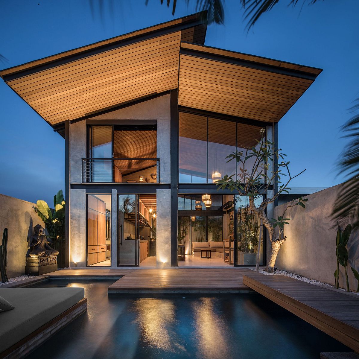 Zen-styled backyard retreat with wooden deck, pool, sunbed along with a statue of buddha on one side