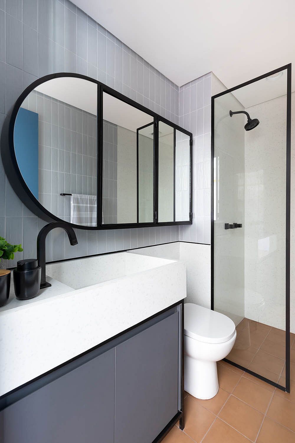 Bathroom in bluish-gray and white along with stylish contemporary mirror