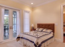 Beige bedroom with large bed and closed doors to the patio