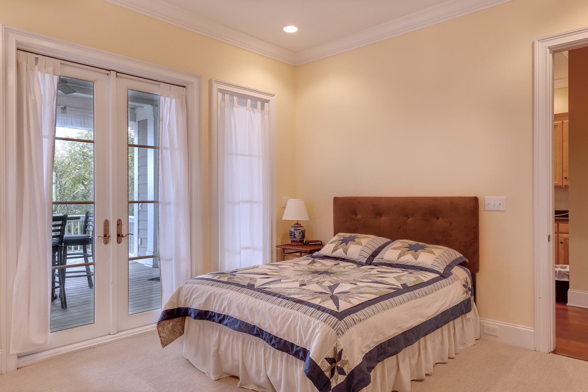 Beige bedroom with large bed and closed doors to the patio