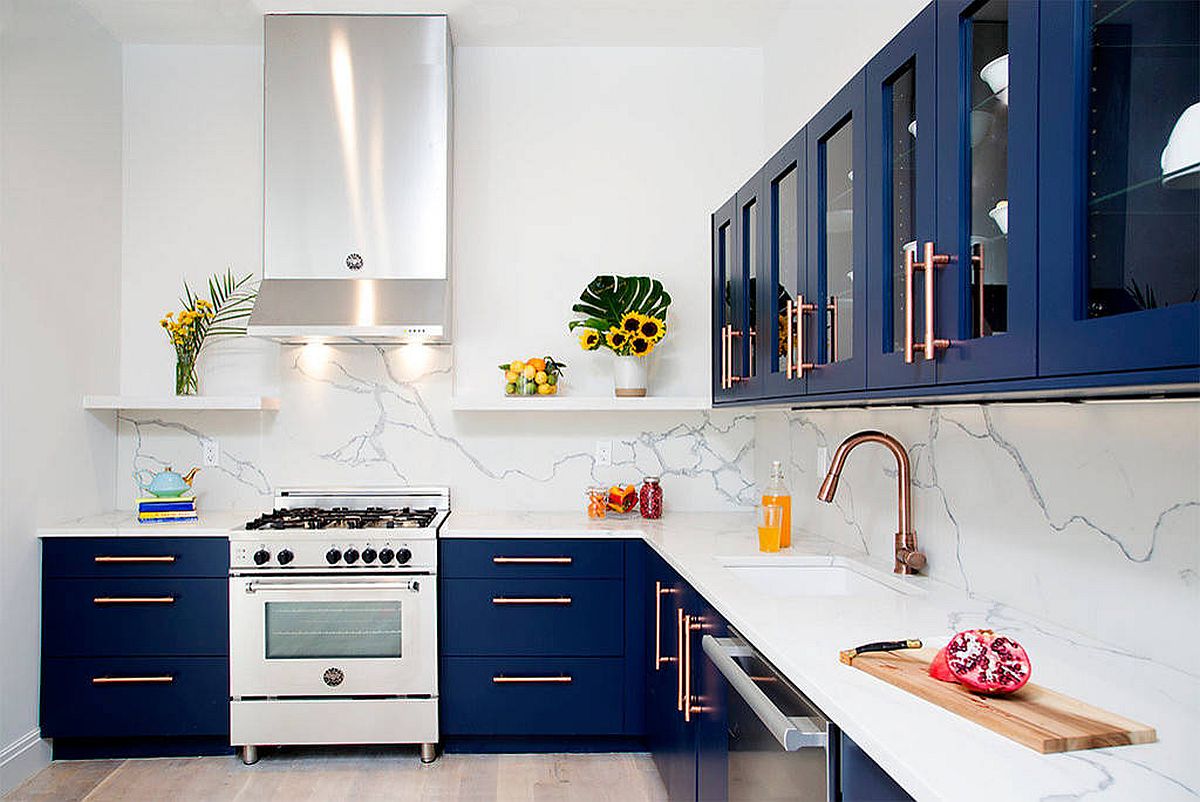 Contemporary I-shaped kitchen with navy blue cabinets, white marble backsplash and brass fixtures