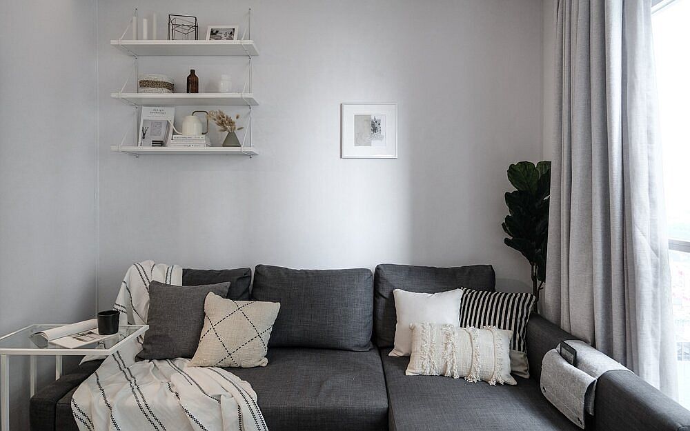 Cozy sectional in gray sits snugly in the corner and also offers additional storage space