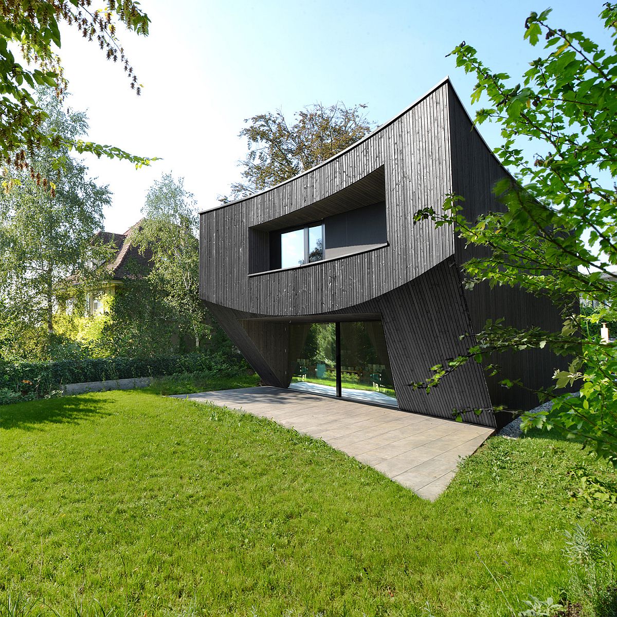 Curved wooden house in Basel with a base that feels different from the mundane homes