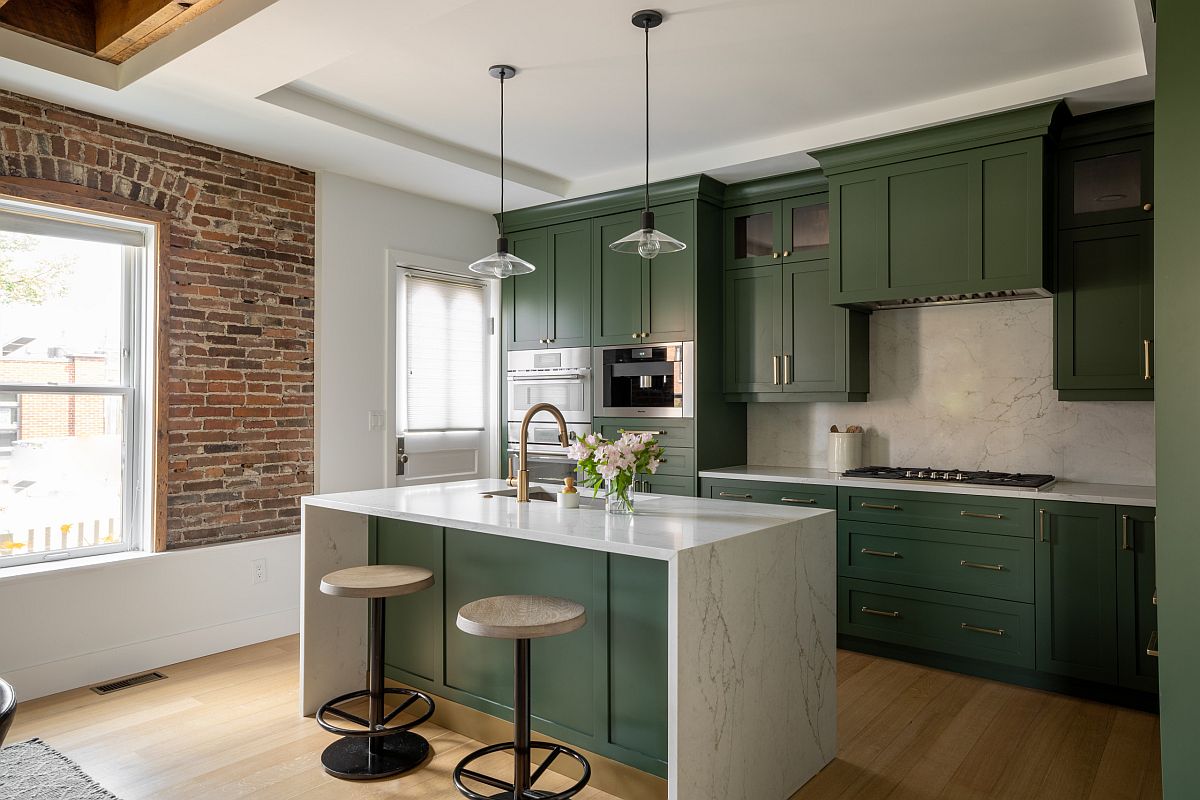 Exquisite dark green kitchens add color to this modern industrial kitchen with an exposed brick wall section