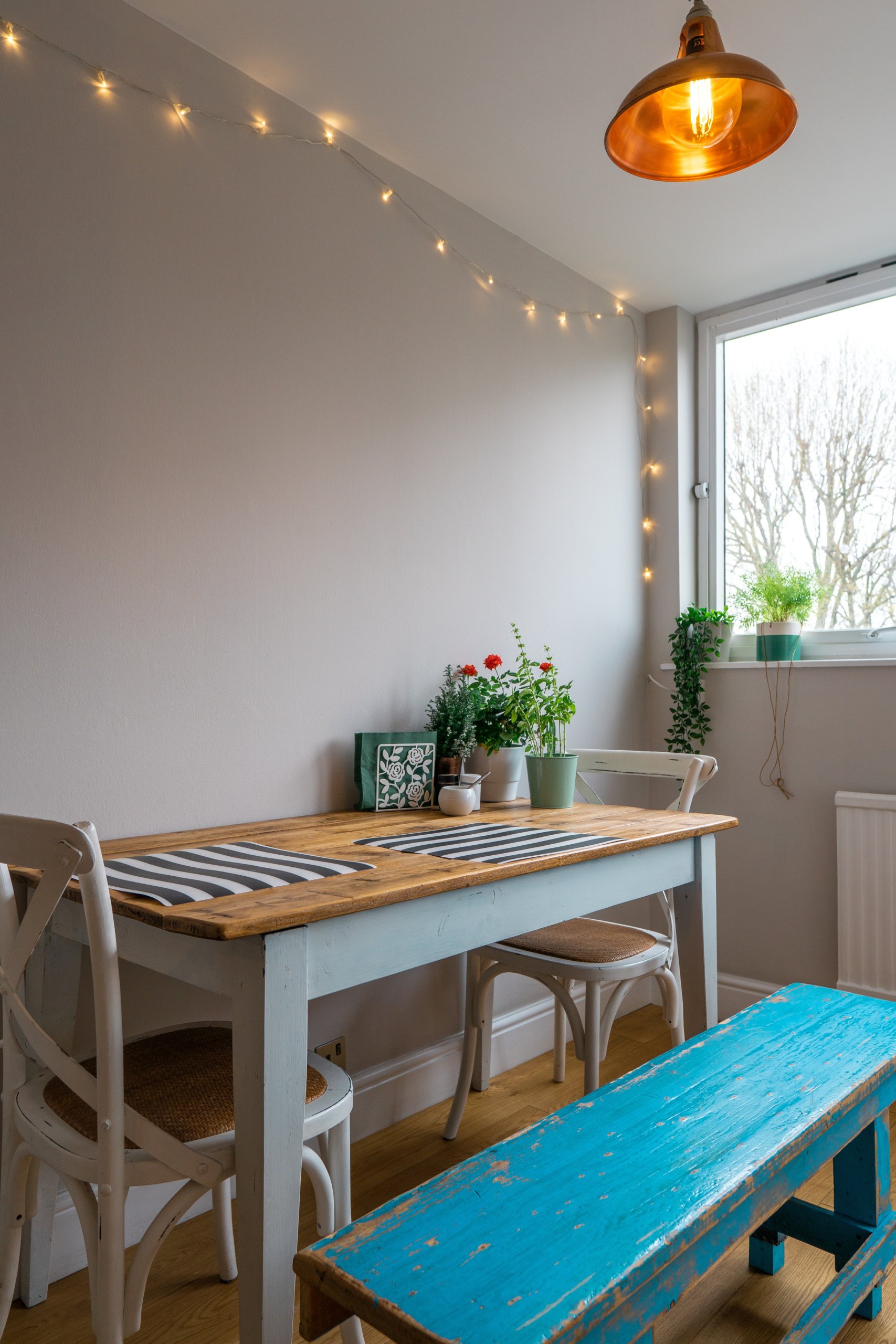 Flower vase on dining table with blue bench