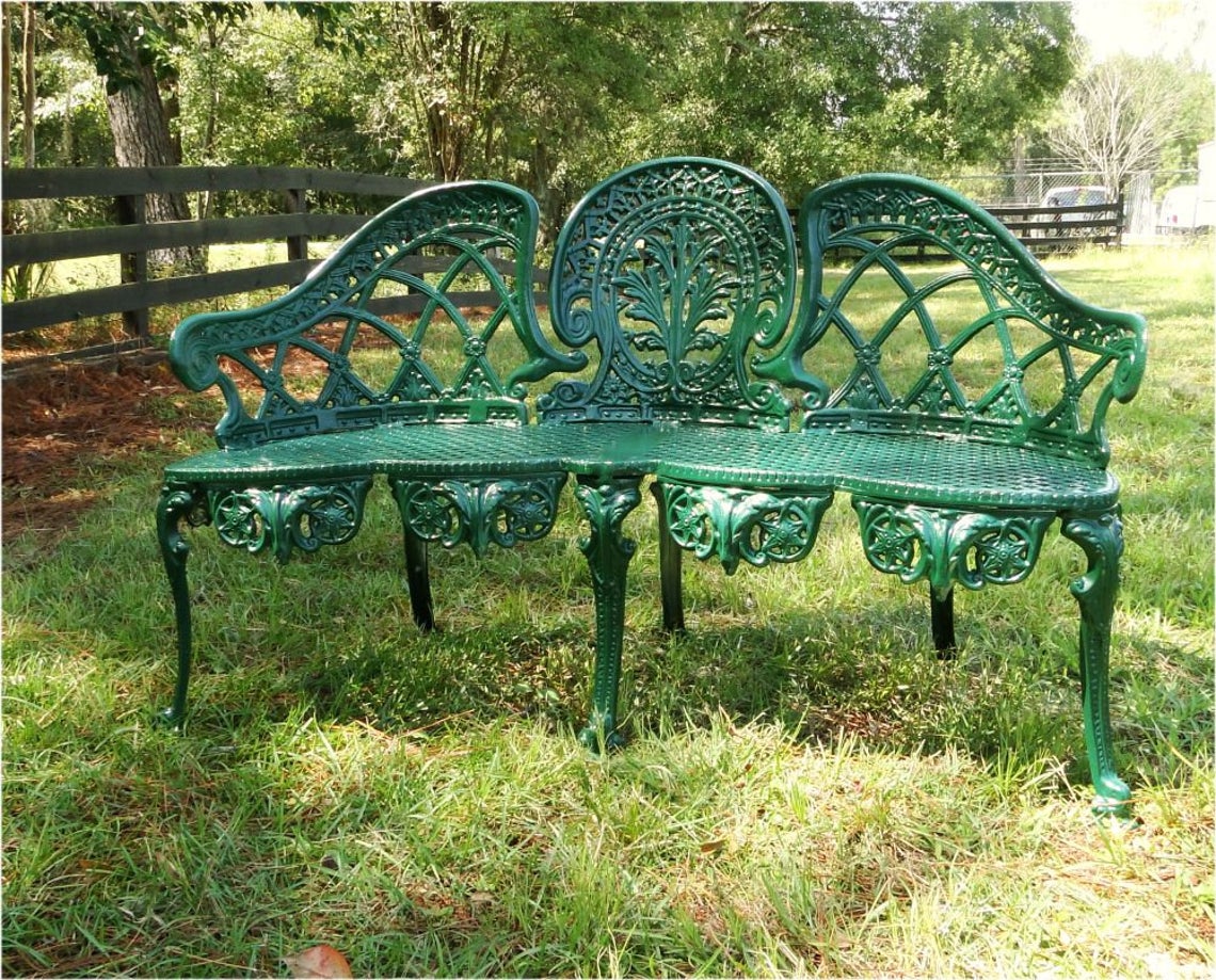 Green metal bench on grass