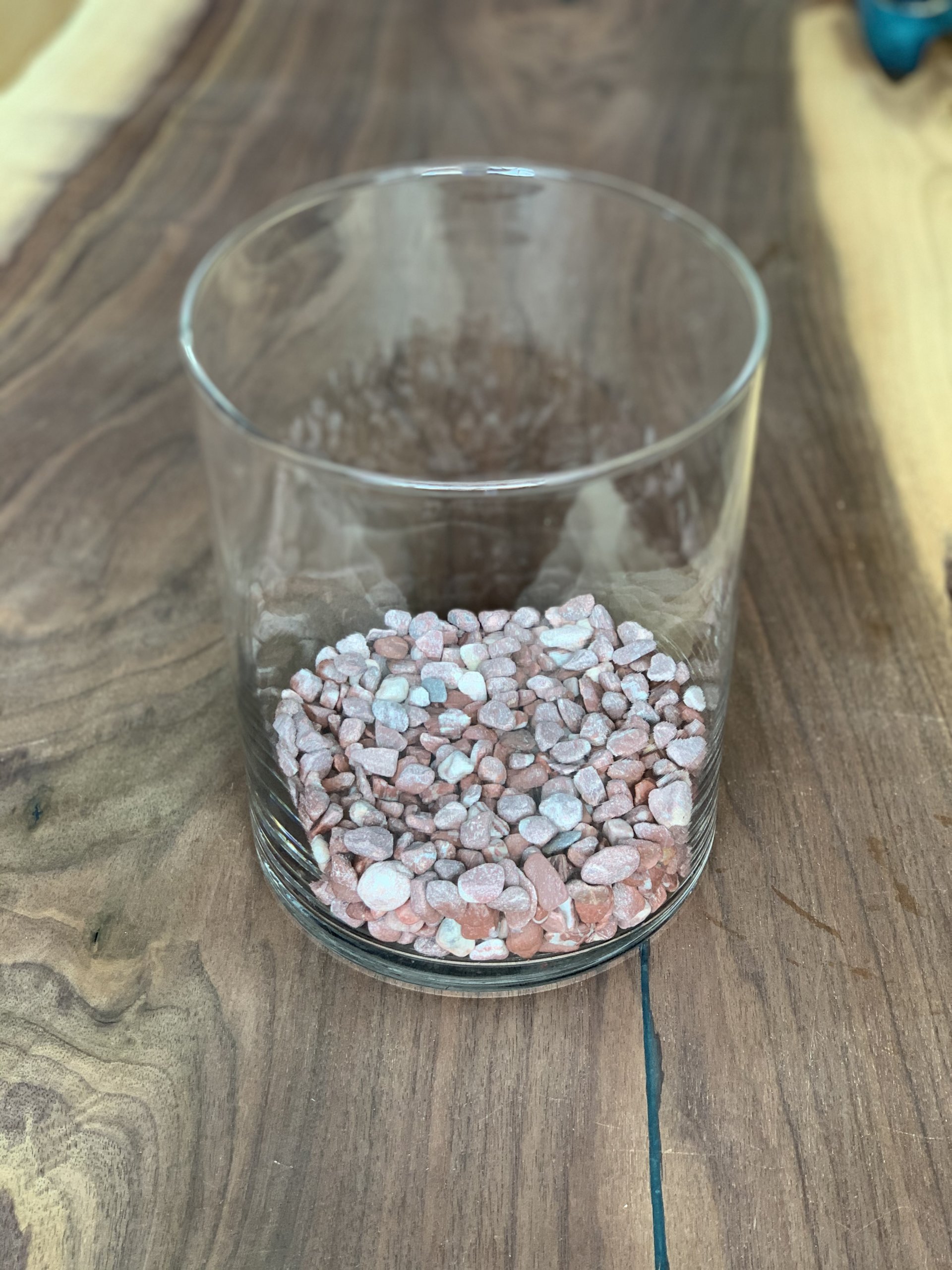 Decorative red and pink stones in glass terrarium