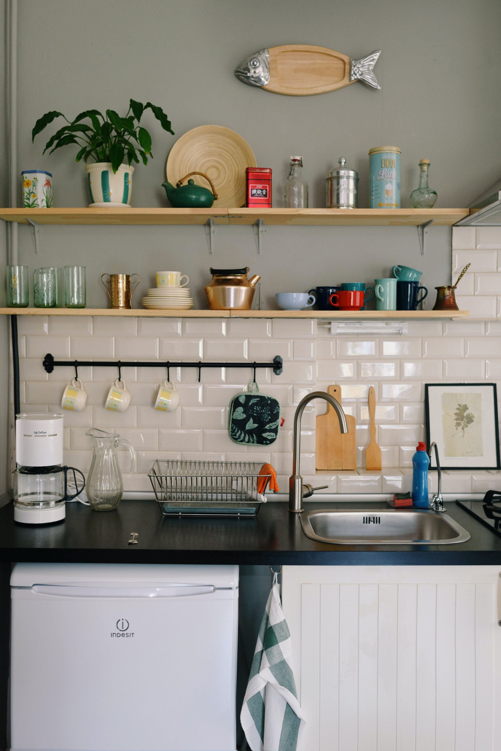 Interior dapur dengan wastafel dan hiasan dinding ikan dari kayu