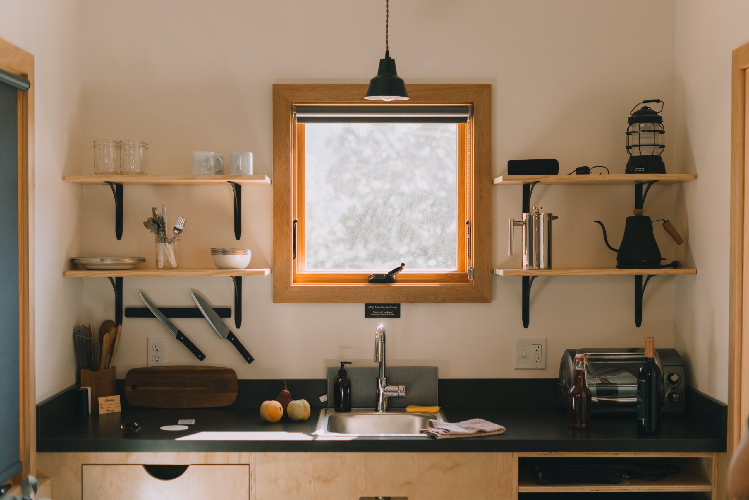 Wastafel dapur dengan jendela persegi dan rak