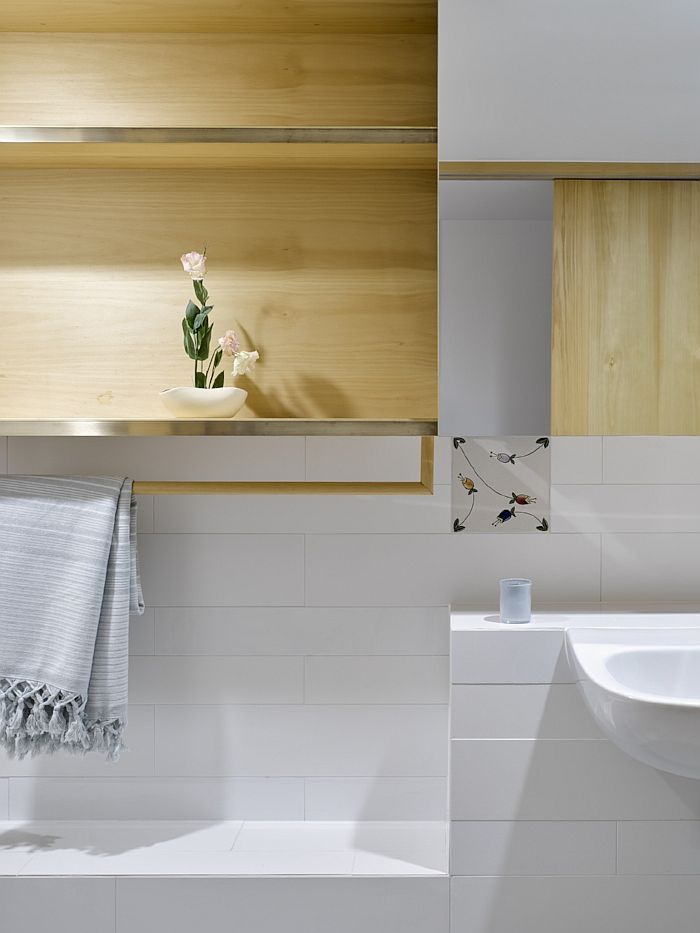 Light wood elements in the bathroom bring elegance and warmth to the white space