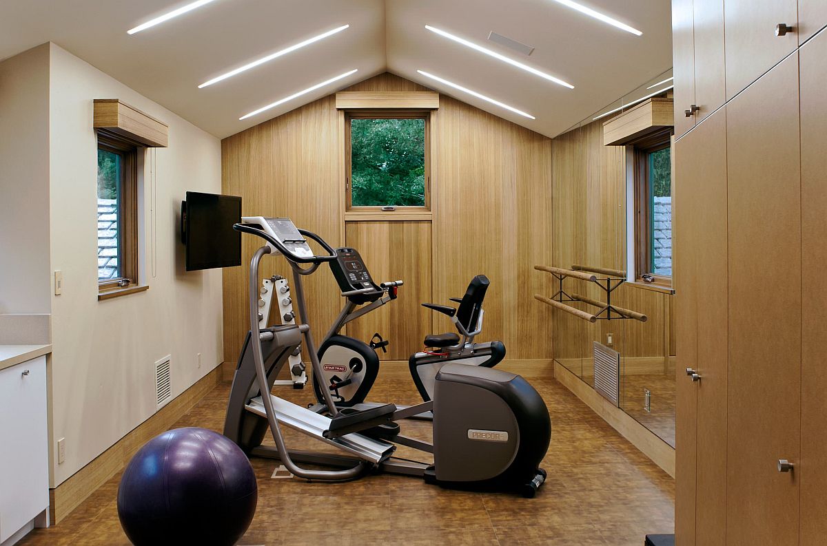 Lighting plays a big role in giving this home gym in white a spacious, modern look