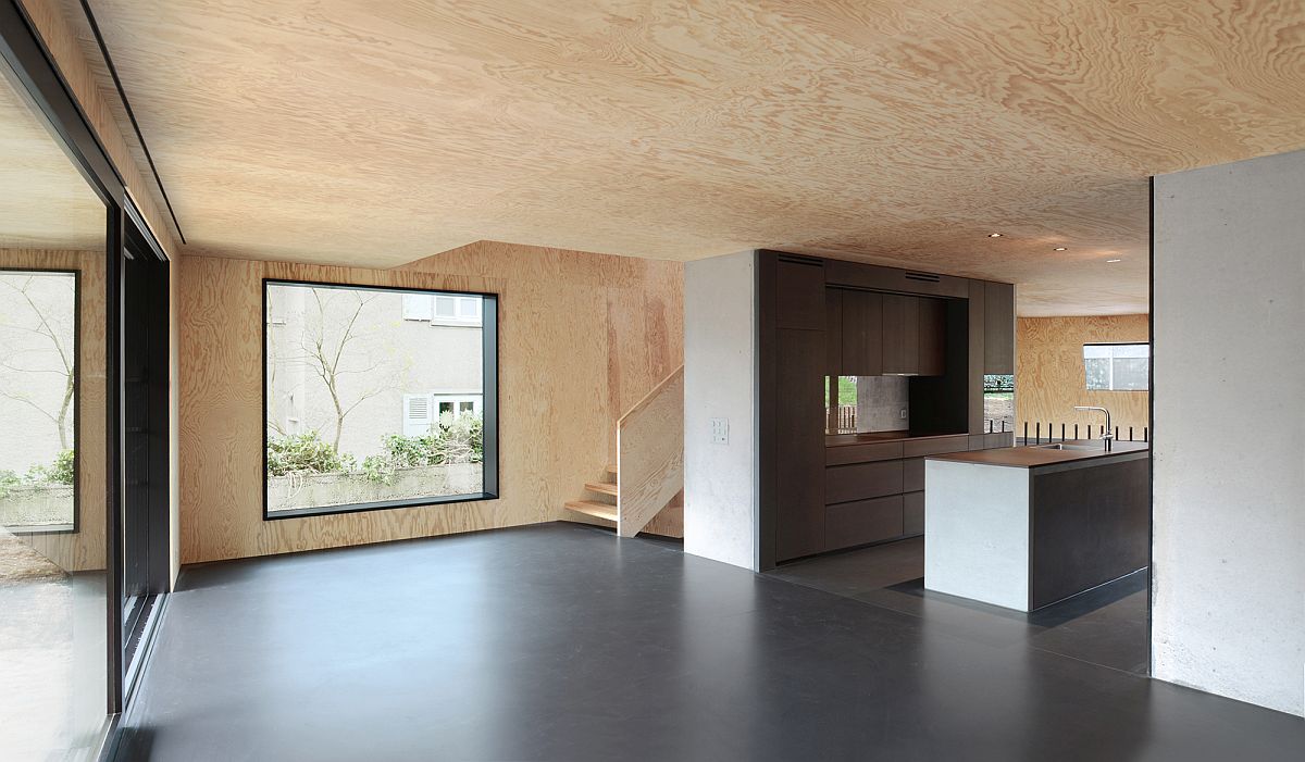 Lower level of the curved house with wooden walls and celing and concrete floor