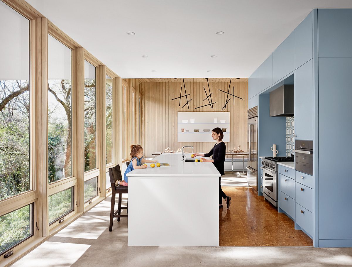 Midcentury modern kitchen with glass walls, blue cabinets and a smart central island