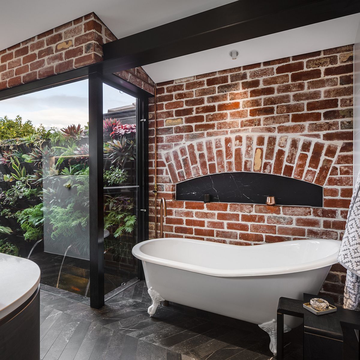 Modern industrial bathroom with a brick wall backdrop and lovely black accents
