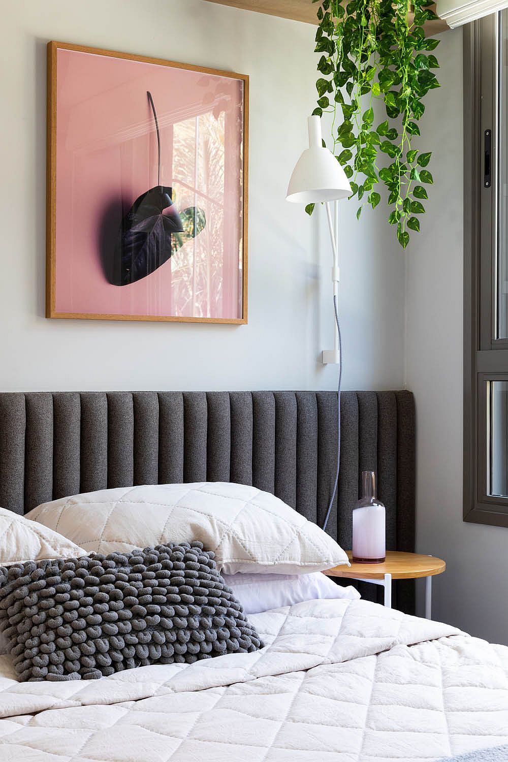 Natural greenery along with framed botanicals brings freshness to the bedroom