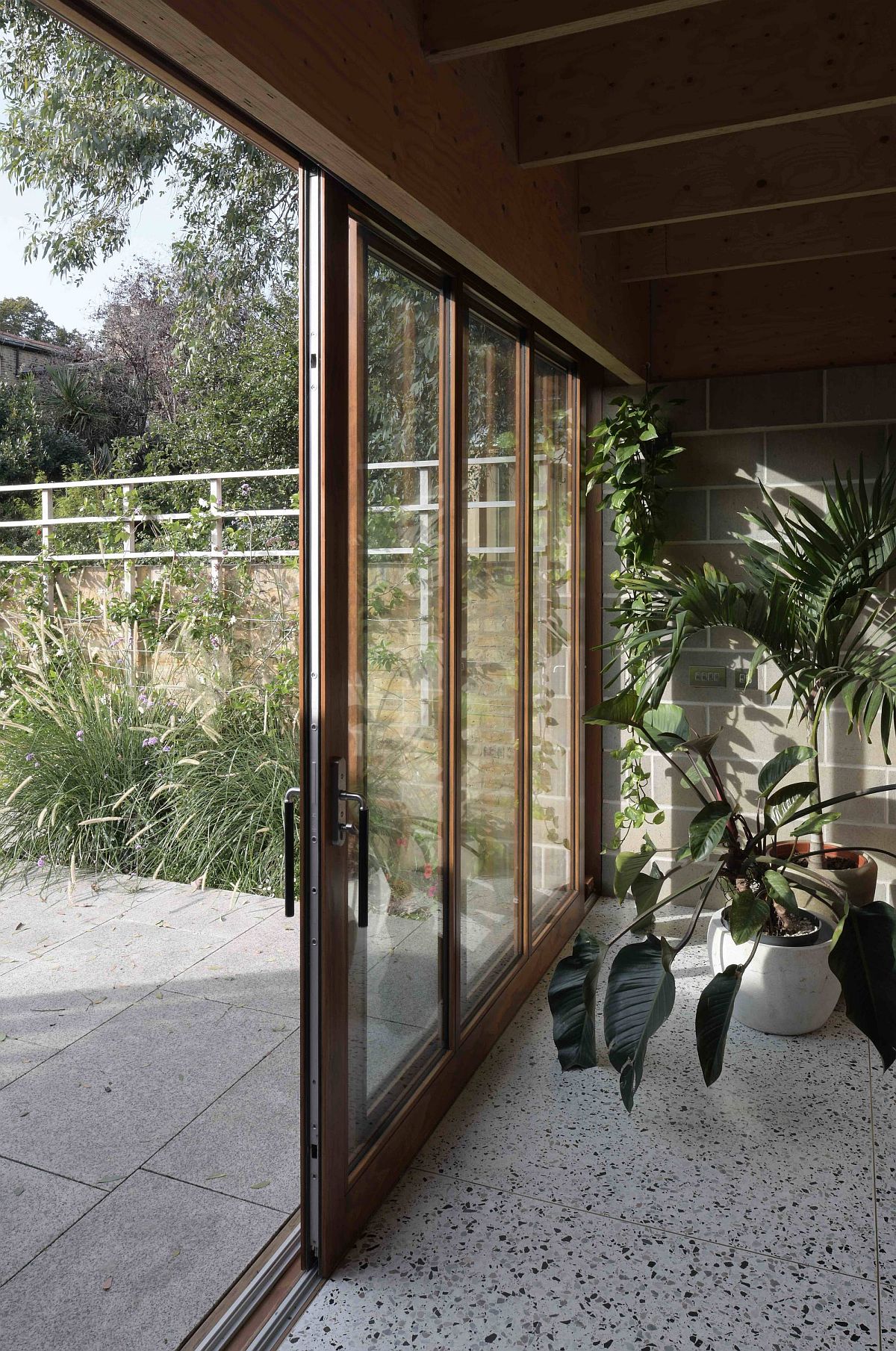 Sliding glass doors connect the interior with the garden outside