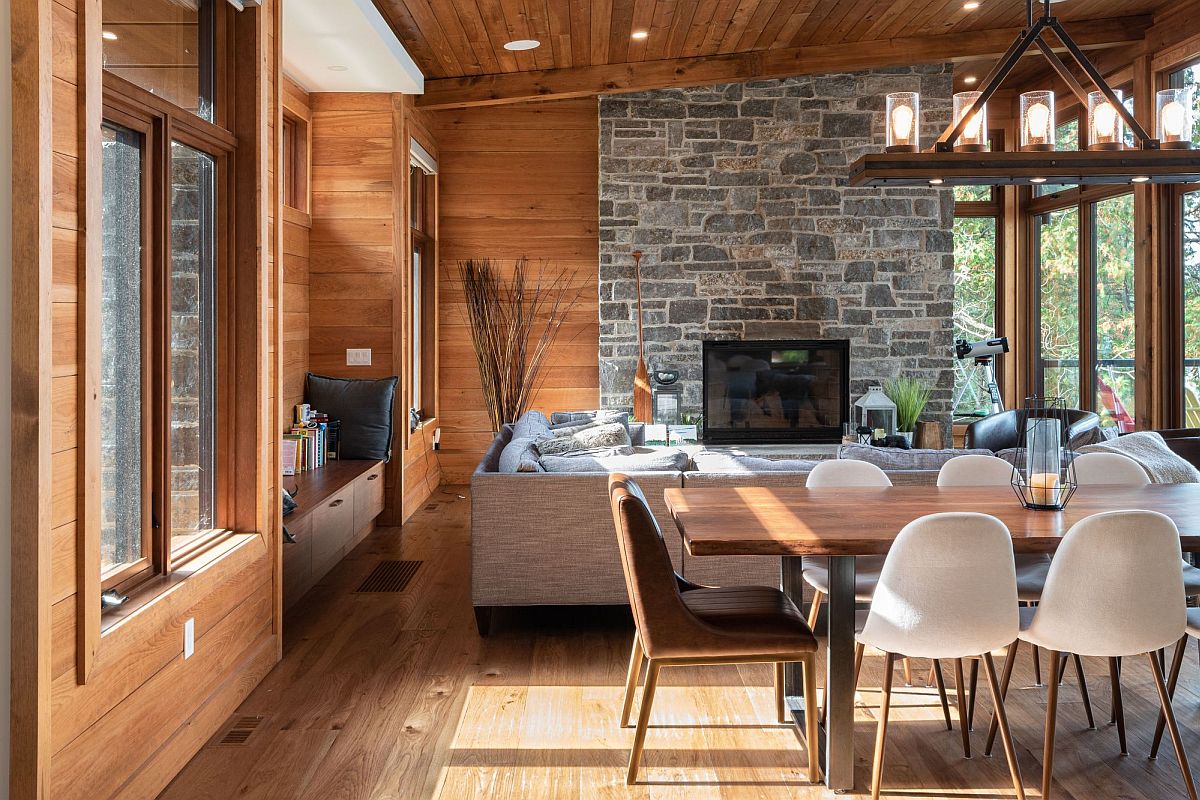 Stone accent wall in the living room with wooden walls makes an impressive statement