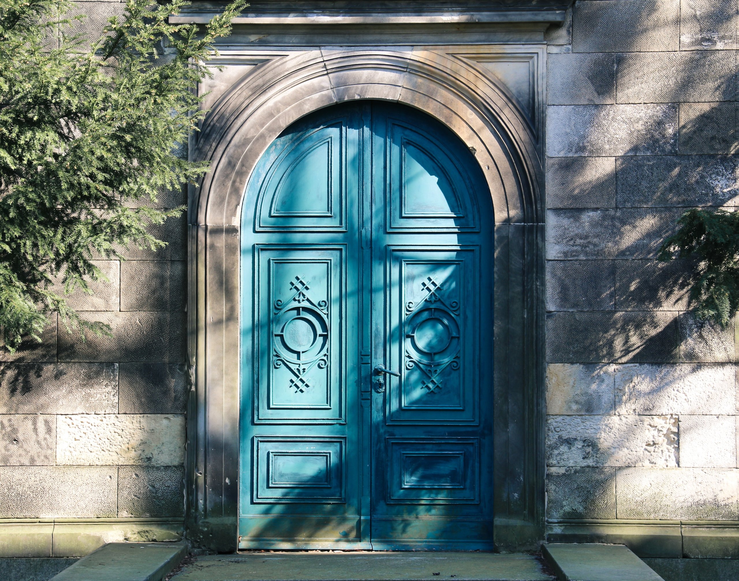 Turquoise arched door in gray wall