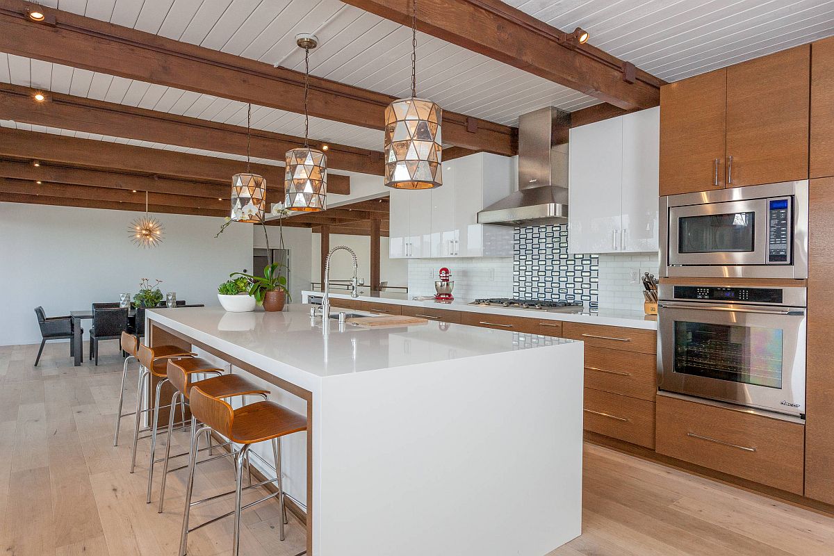 Wooden kitchen cabinets coupled with white island in the spacious midcentury kitchen