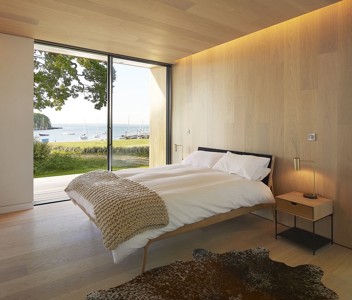 Wooden walls and ceiling along with cozy lighting and wonderful English Channel views for the bedroom